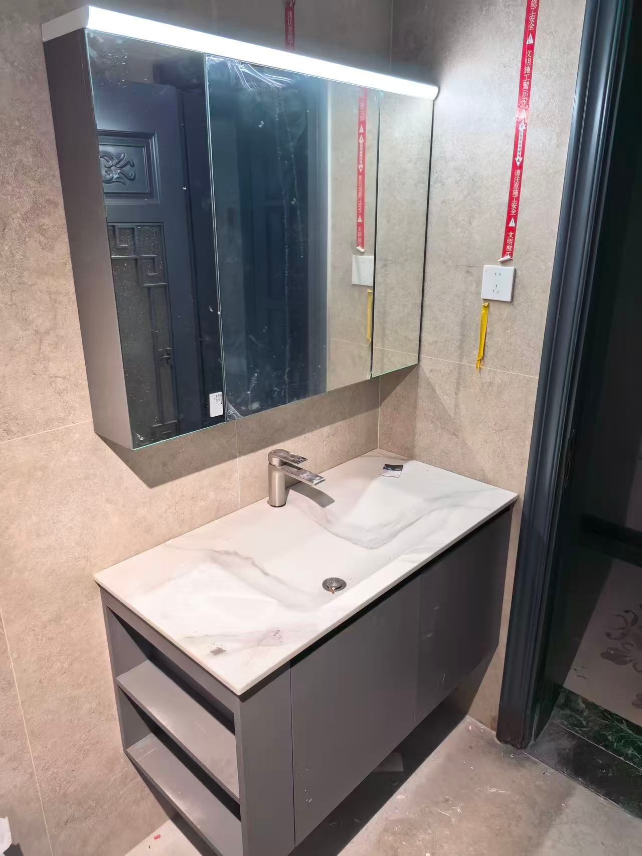 Master bathroom vanity with light wood-grain cabinet and LED mirror
