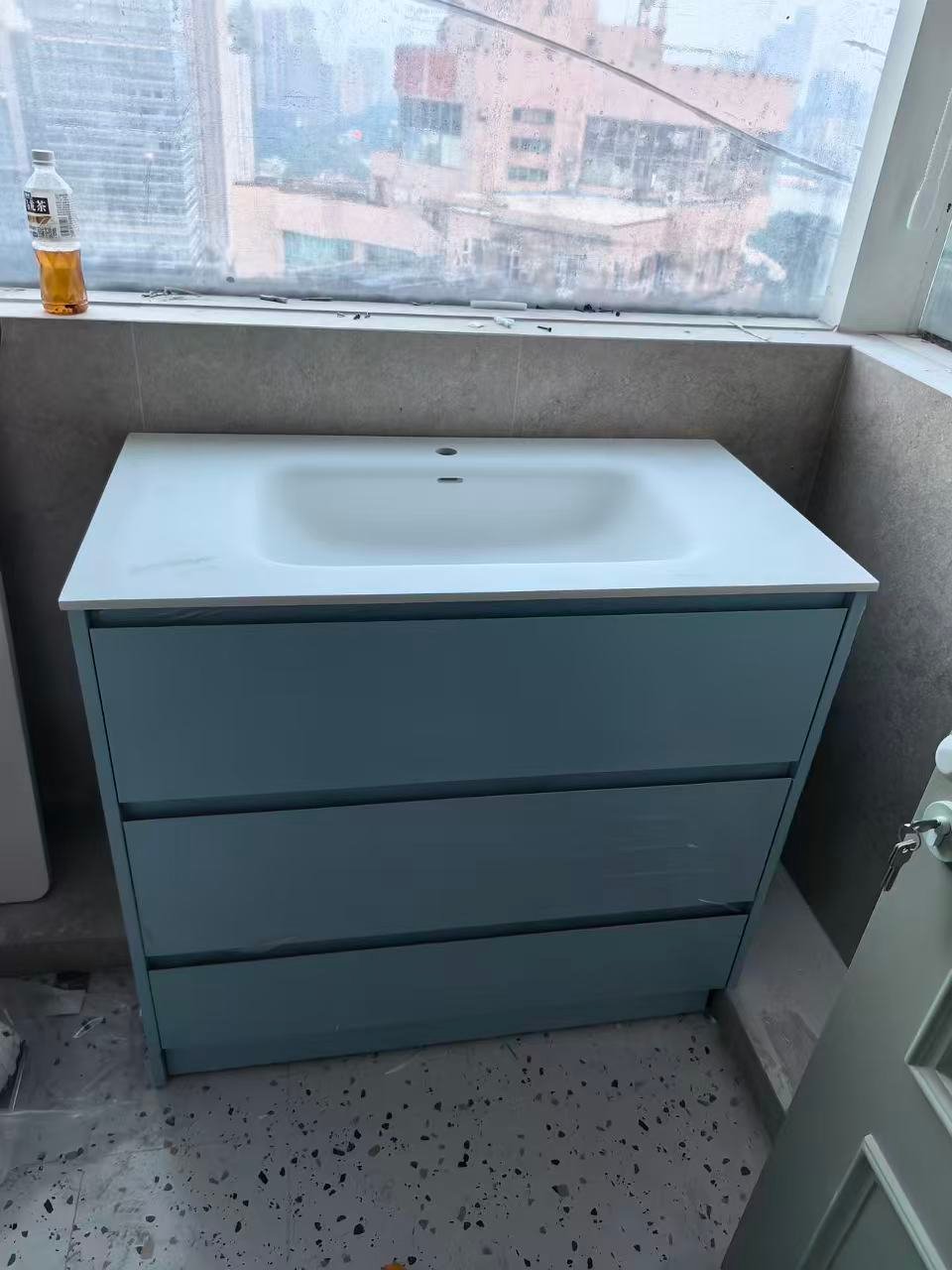 Blue bathroom vanity drawer cabinet with window view