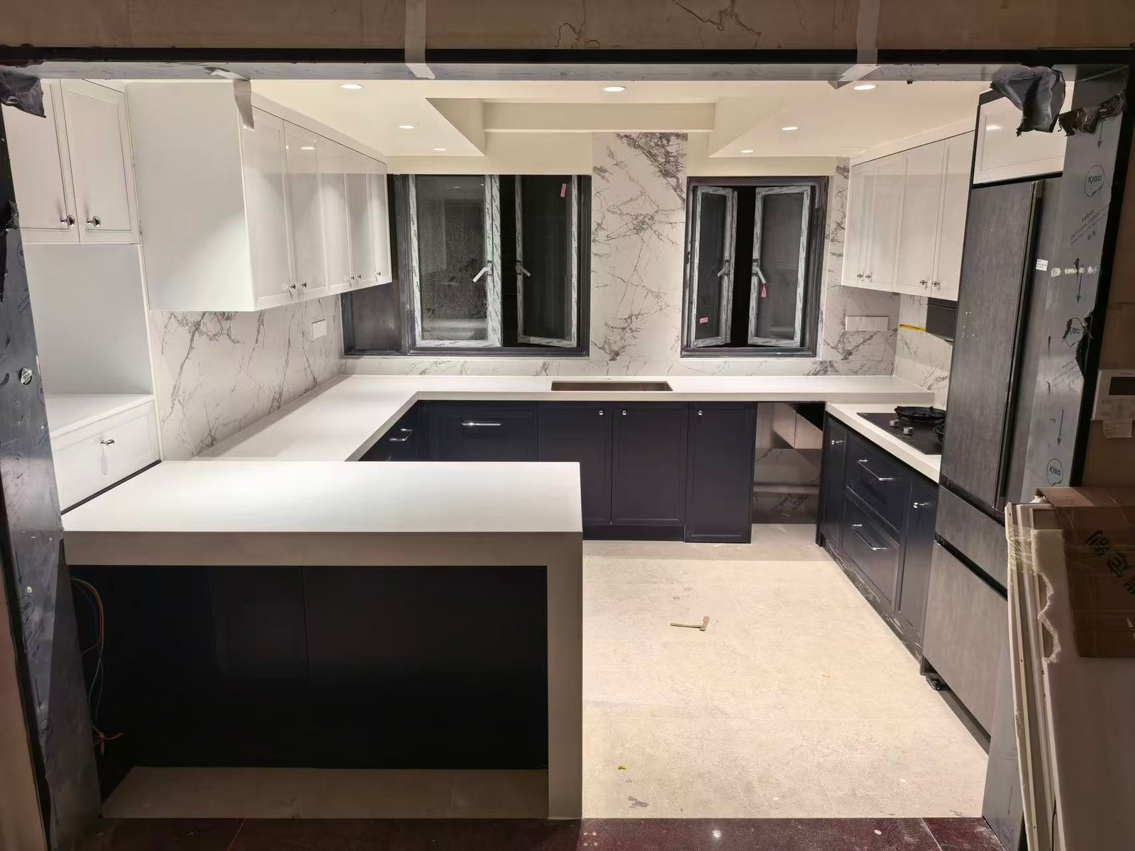 Full view of the L-shaped luxury kitchen with custom island and integrated fridge cabinetry