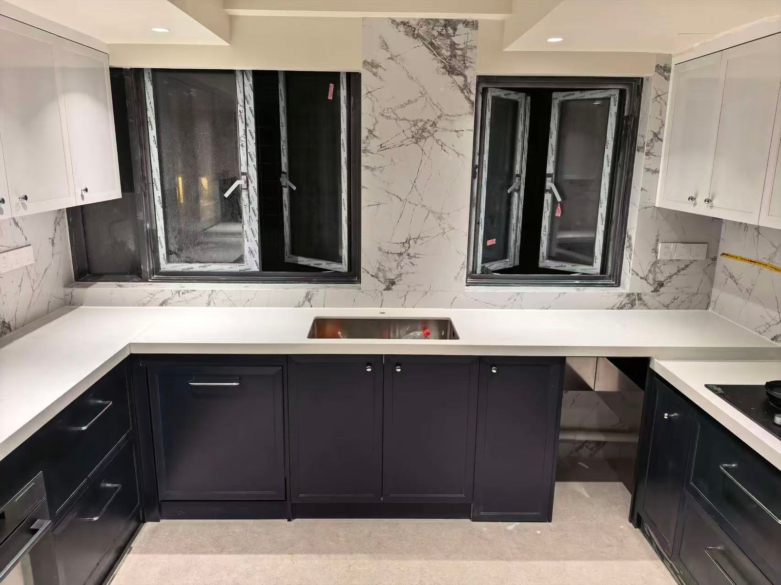 L-shaped kitchen cabinet run with double window and sink